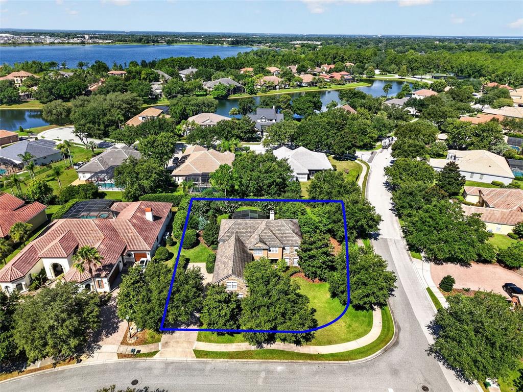 A two-story house with stone veneer and stucco siding features a brick walkway and lawn — 3000 ISOLA BELLA BOULEVARD, MOUNT DORA, FL