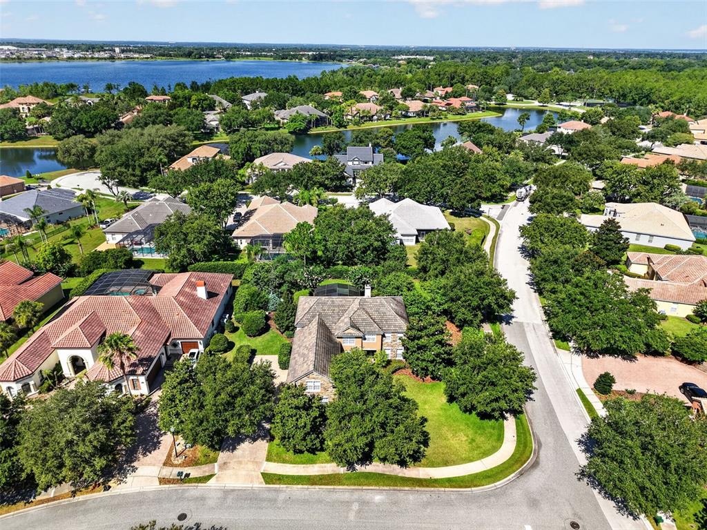 A paved walkway leads to the green double front doors of a two-story stucco home — 3000 ISOLA BELLA BOULEVARD, MOUNT DORA, FL