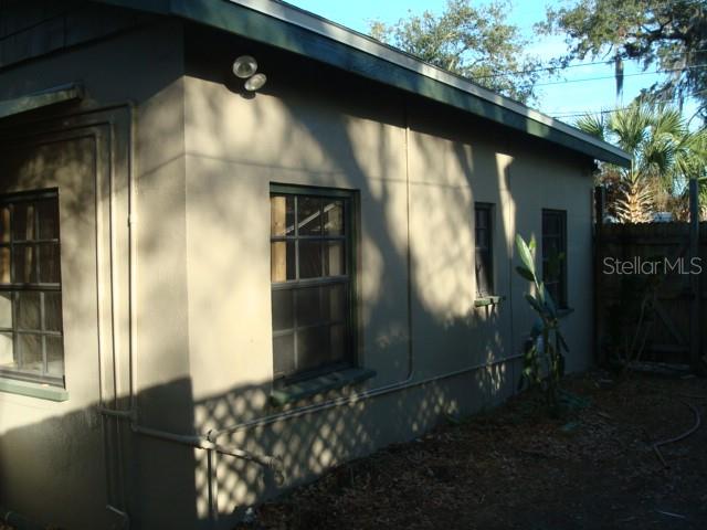 The exterior of a tan stucco building features dark-framed windows and a dark roofline — 2135 8TH AVENUE N UNIT 2, ST PETERSBURG, FL