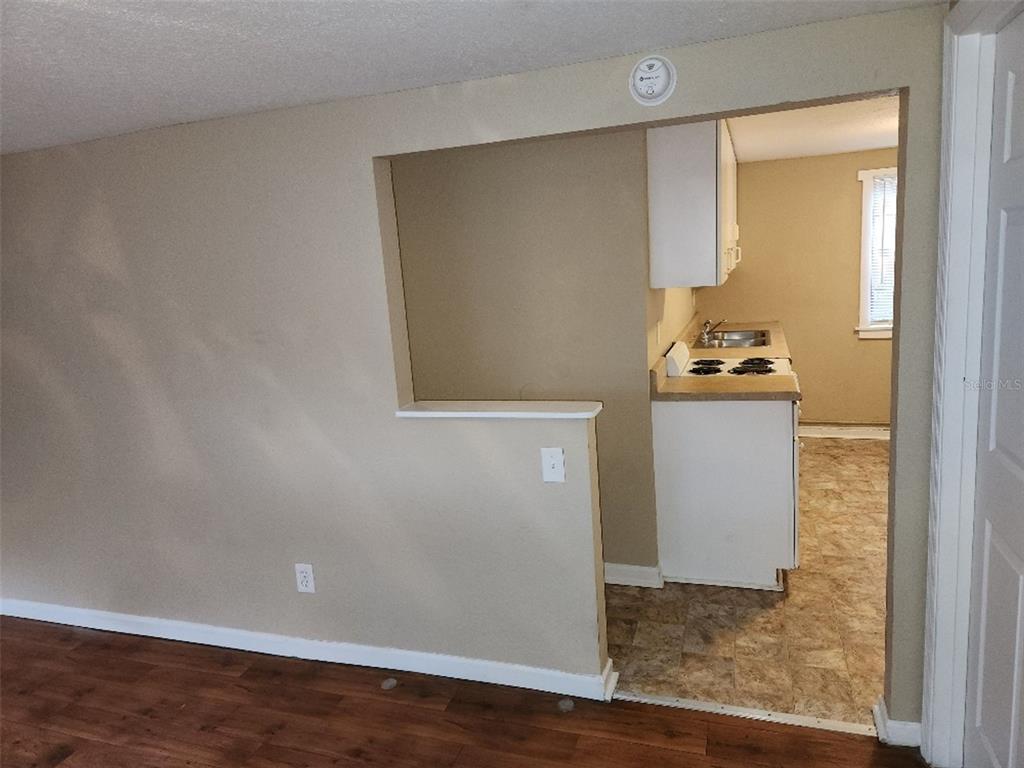 A view from a living room into a kitchen with a pass-through wall opening — 2135 8TH AVENUE N UNIT 2, ST PETERSBURG, FL