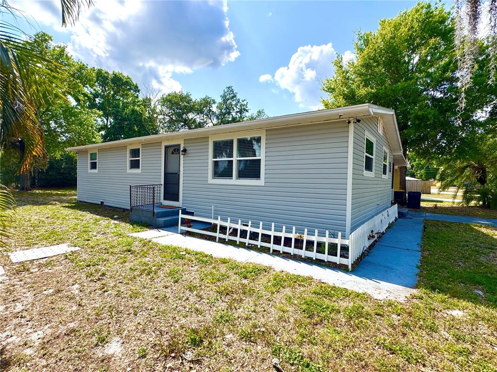 A covered porch features a wooden bench, a small table, and a screen enclosure — 111 NE PALENCIA ROAD, AUBURNDALE, FL