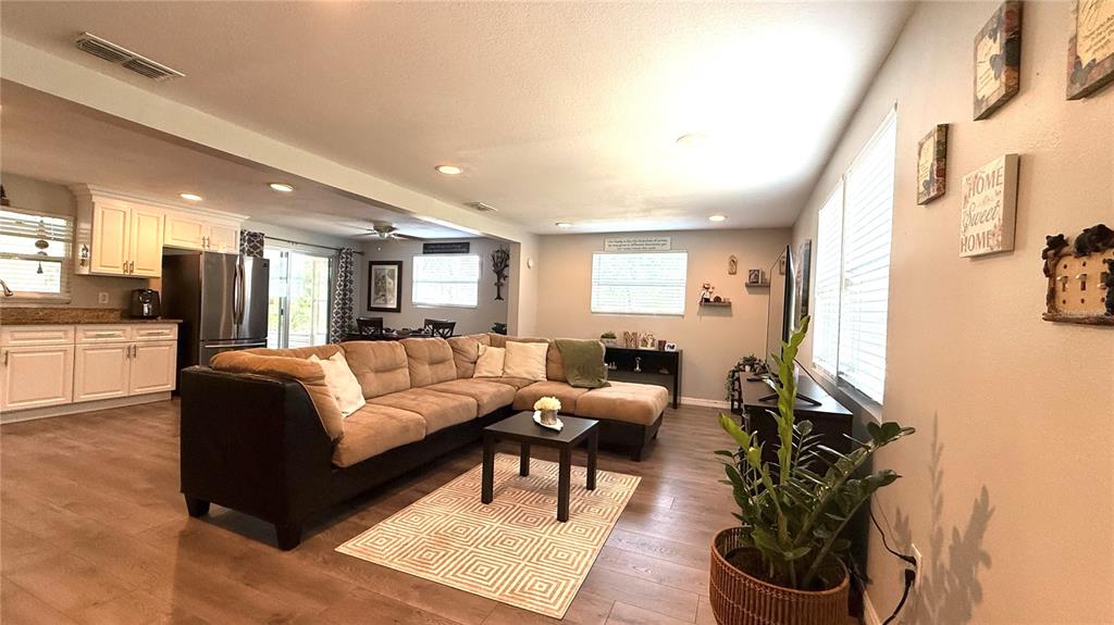 A screened-in porch features a wooden table, bench, bar stools, and a concrete floor — 111 NE PALENCIA ROAD, AUBURNDALE, FL