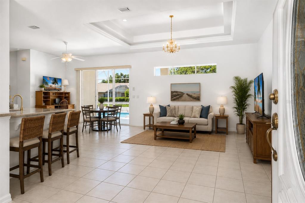 A kitchen with light wood cabinets, gray countertops, tile flooring, and a breakfast bar — 25 WESTMINSTER DRIVE, PALM COAST, FL