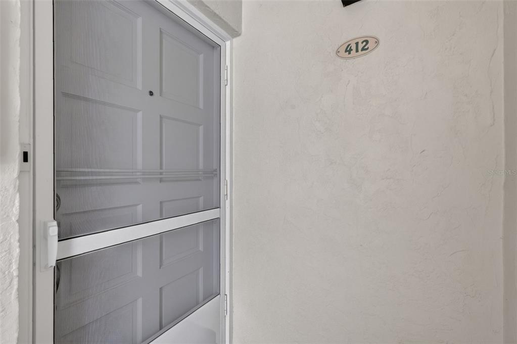 A white door with a screen door and the number 412 on the wall — 101 N GRANDVIEW STREET UNIT 412, MOUNT DORA, FL