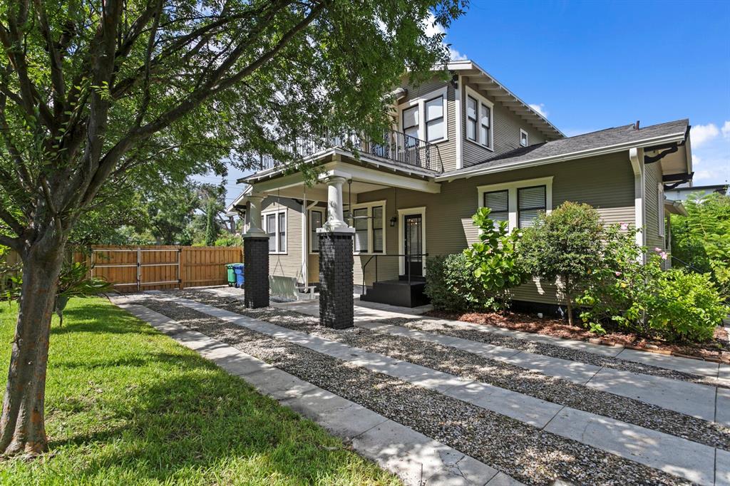A two-story house with a covered porch, brick columns, and a gravel and concrete driveway — 705 W WEST STREET, TAMPA, FL