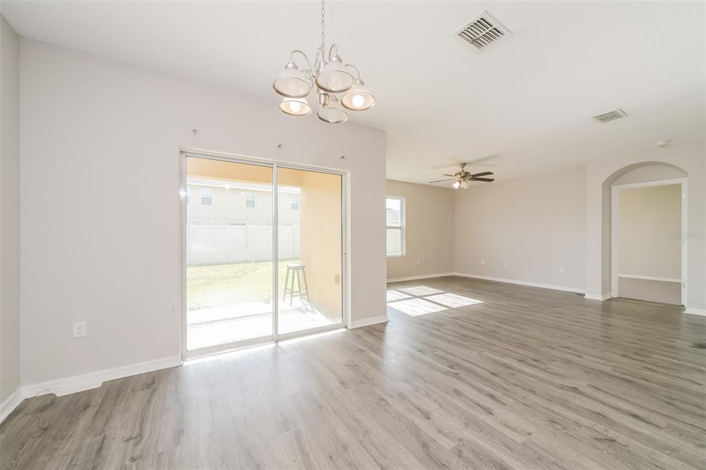 A dining area with a chandelier and sliding glass doors leading to a backyard patio — 2301 SEQUOIA WAY, DAVENPORT, FL