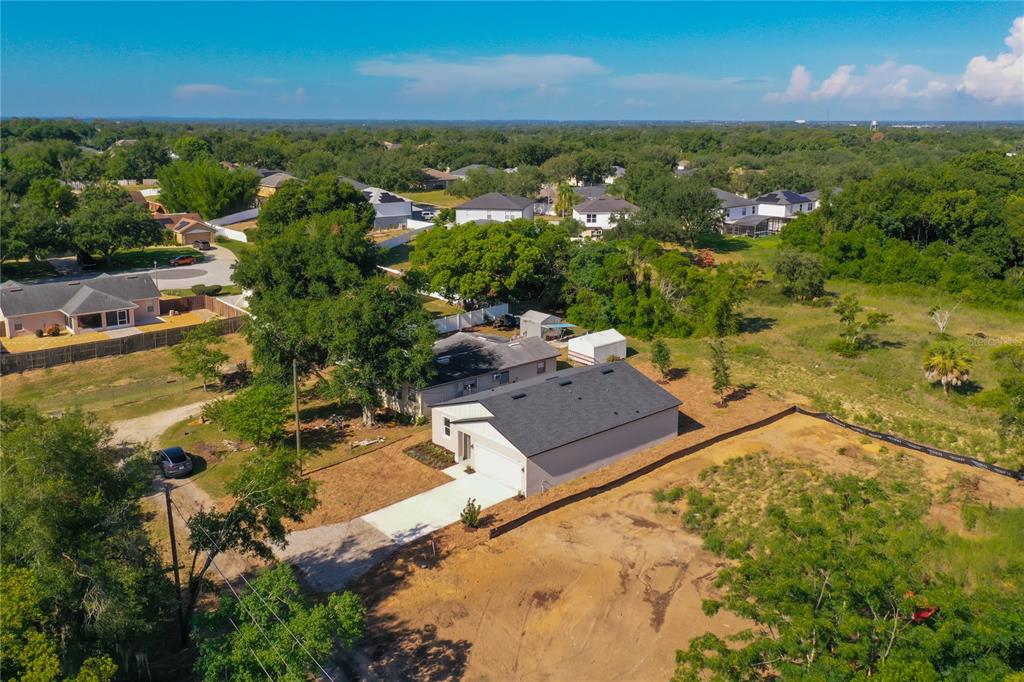 An aerial view shows a house with a dark roof and a concrete driveway — 110 FRUITWOOD AVENUE, EUSTIS, FL