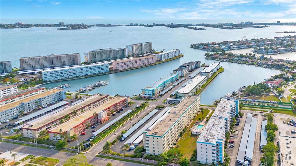 An aerial view shows a multi-story apartment building with a large parking lot and carports — 2960 59TH STREET S UNIT 405, GULFPORT, FL