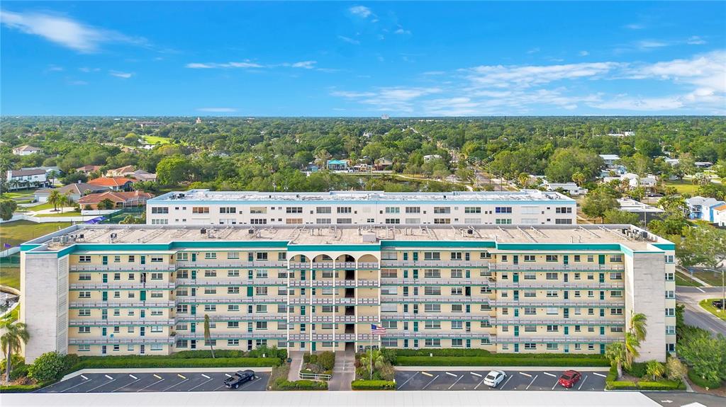 A bright room with wood-look flooring, a mirrored closet, a chandelier, and a ceiling fan — 2960 59TH STREET S UNIT 405, GULFPORT, FL