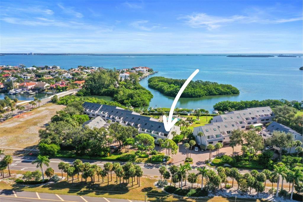 An aerial view of a multi-story residential complex situated near a bay and mangroves — 1355 PINELLAS BAYWAY S UNIT 19, TIERRA VERDE, FL