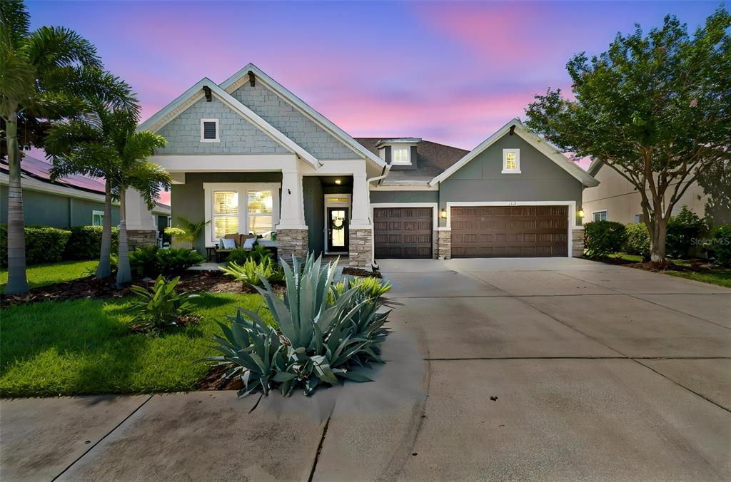 A screened-in patio features outdoor furniture, a fire pit, and a view of a lake — 7223 HOURGLASS DRIVE, APOLLO BEACH, FL