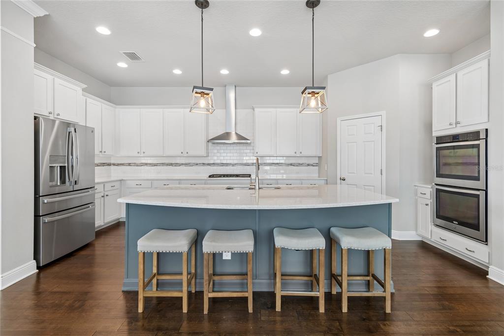A living room with a large sectional sofa, dark wood floors, and sliding glass doors — 7223 HOURGLASS DRIVE, APOLLO BEACH, FL