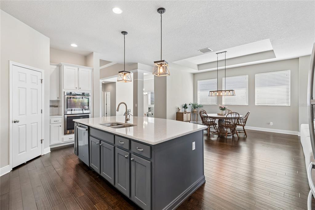 A living room features a large sectional sofa, a television on a wooden console, and sliding glass doors — 7223 HOURGLASS DRIVE, APOLLO BEACH, FL