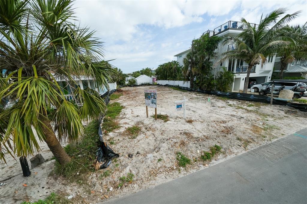 An aerial view shows two houses near a body of water with a road in front — 106 S 11TH, BRADENTON BEACH, FL