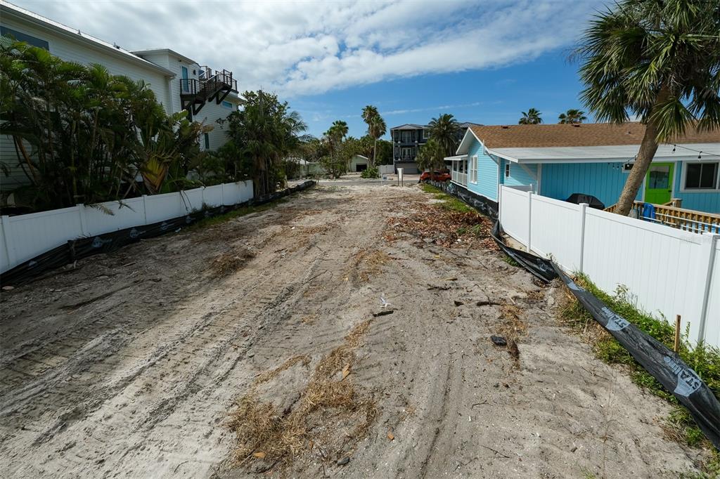 An aerial view shows a coastal neighborhood with a red circle highlighting a specific house — 106 S 11TH, BRADENTON BEACH, FL
