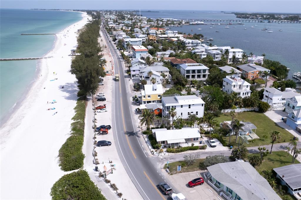 A sandy path leads through dunes toward a lifeguard tower on a sunny beach — 106 S 11TH, BRADENTON BEACH, FL