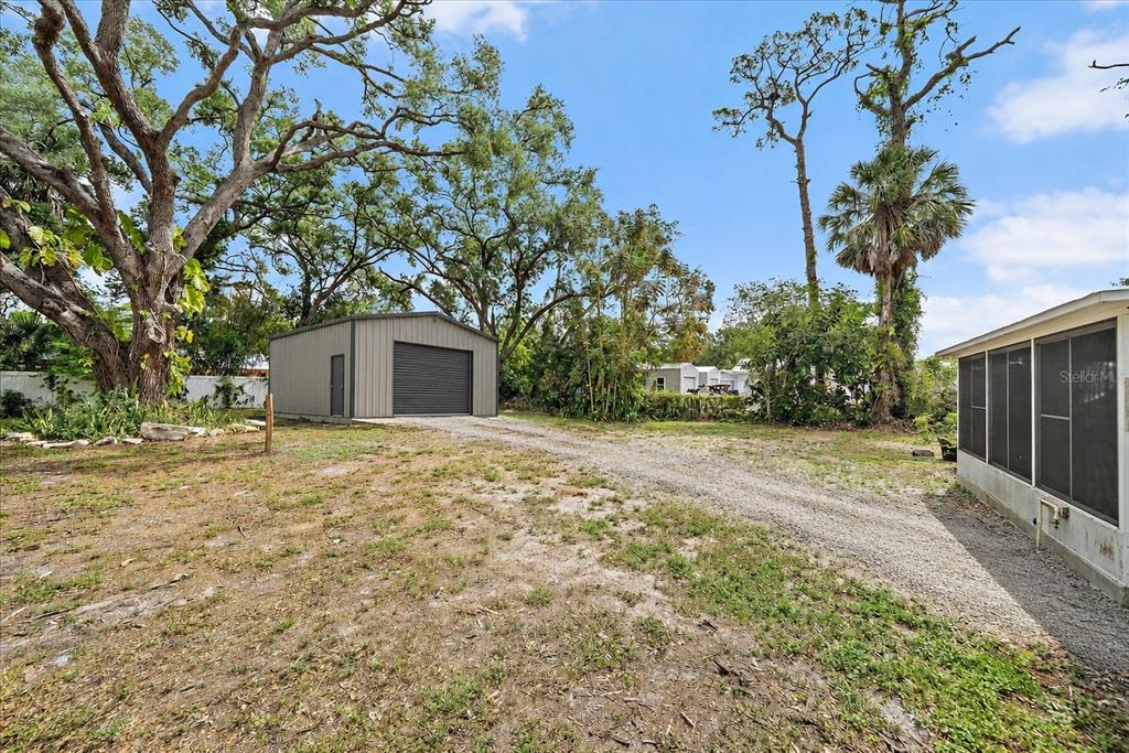 A bedroom features a wooden bed, a dresser with a mirror, and light-colored tile flooring — 2503 53RD AVENUE W, BRADENTON, FL
