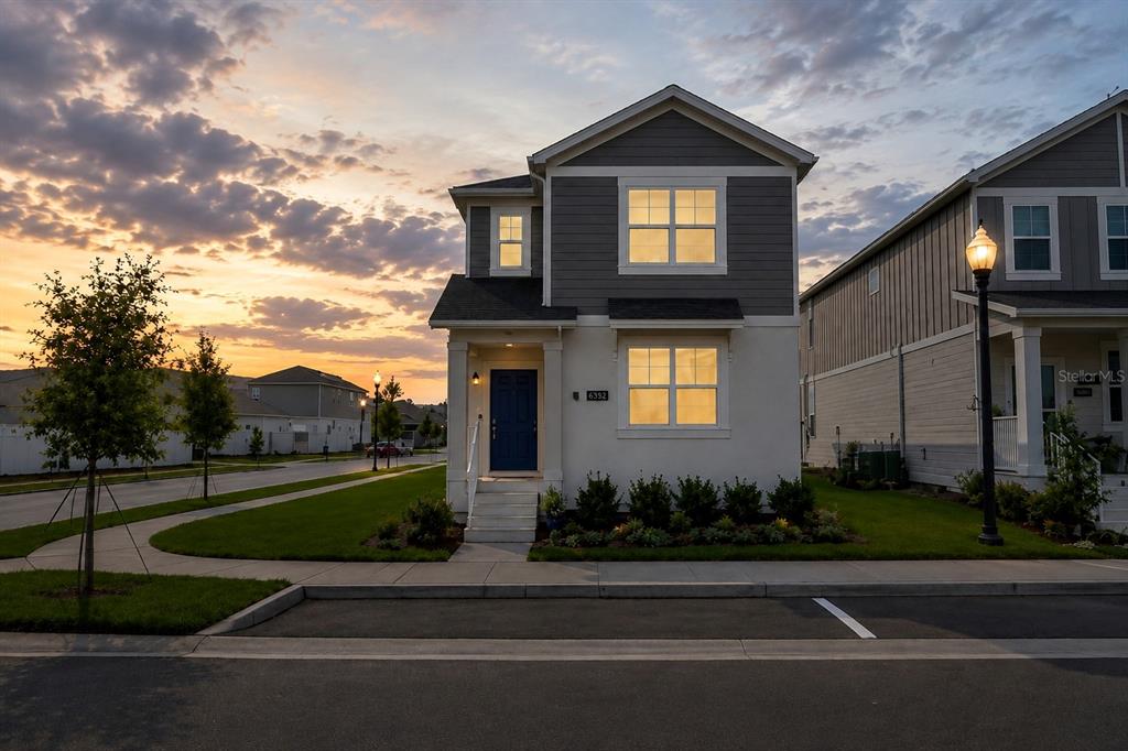 A two-story house with a blue front door, gray siding, and a white stucco exterior — 6352 SPRUCEPINE LANE, ST CLOUD, FL