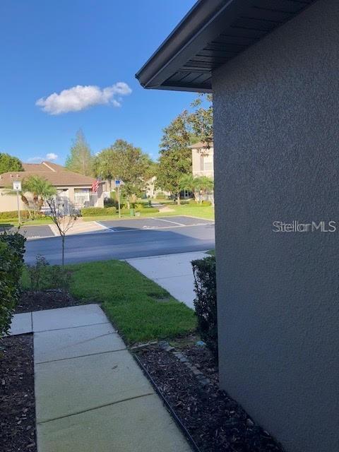 A view from a sidewalk looking toward a parking lot and neighboring houses — 169 CONSTITUTION WAY, WINTER SPRINGS, FL
