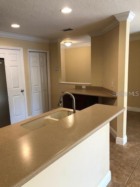 A kitchen features a tan countertop, a double-basin sink, and a pass-through window — 169 CONSTITUTION WAY, WINTER SPRINGS, FL