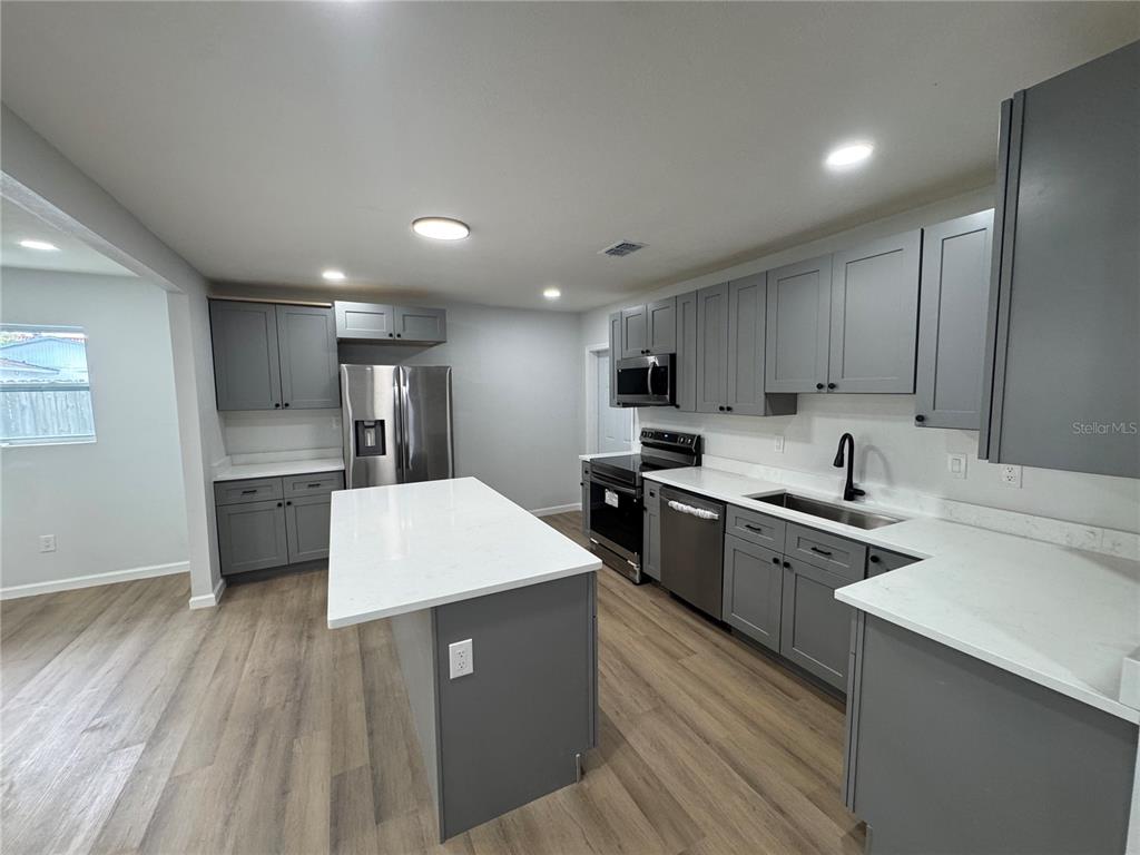 A dining area with a table and chairs features light wood flooring and white walls — 1407 MOSELLE AVENUE, ORLANDO, FL