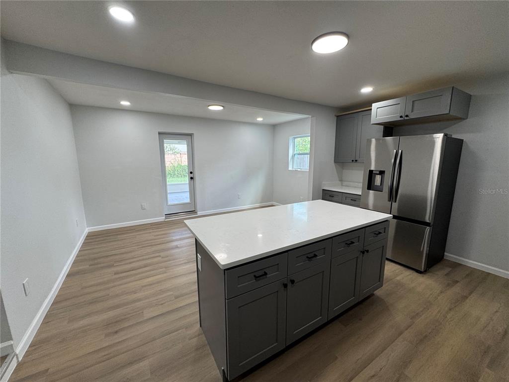 A room with wood-look flooring, a ceiling fan, a sliding glass door, and a screened porch — 1407 MOSELLE AVENUE, ORLANDO, FL