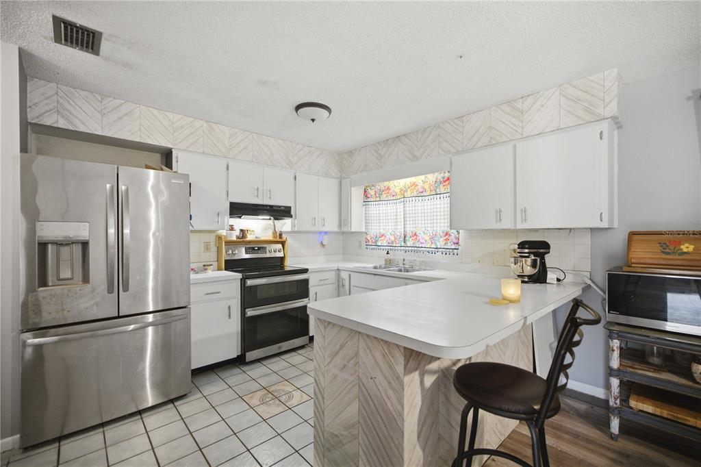 A single-story house with a white stucco exterior, a carport, and a concrete driveway — 477 SPRING LANE, OCALA, FL