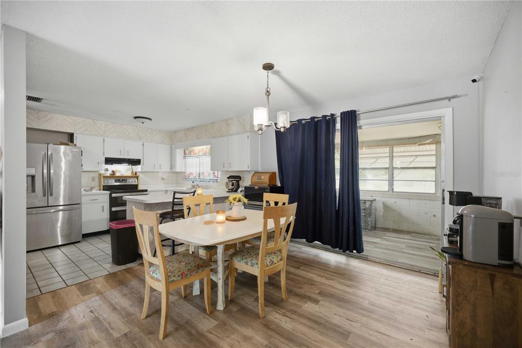 An empty room with light gray walls, wood-look flooring, track lighting, and three large windows — 477 SPRING LANE, OCALA, FL