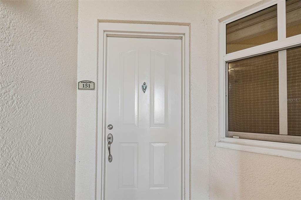 A tiled entryway leads to a bathroom and a room with hardwood flooring — 12033 GANDY BOULEVARD N UNIT 151, ST PETERSBURG, FL