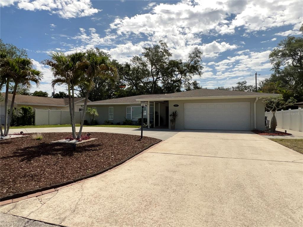 A single-story house with a concrete driveway, palm trees, and a two-car garage — 855 FOUNTAINHEAD DRIVE, LARGO, FL