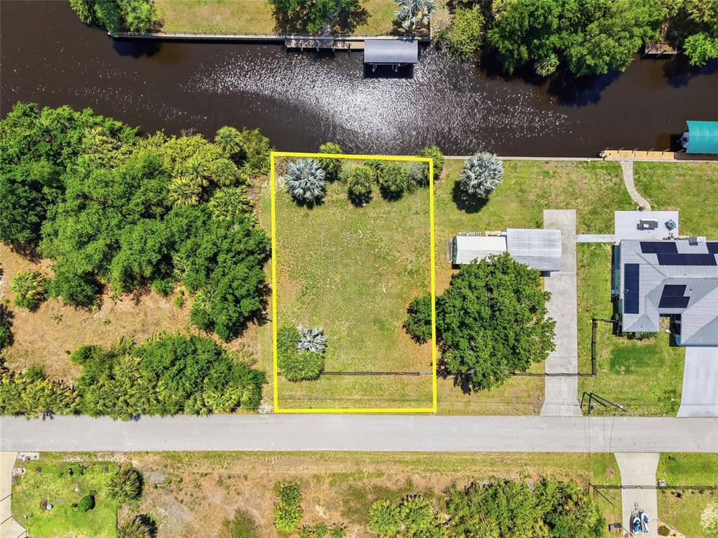An aerial view shows a rectangular vacant lot bordered by a road and a canal — 28451 SABAL PALM DRIVE, PUNTA GORDA, FL