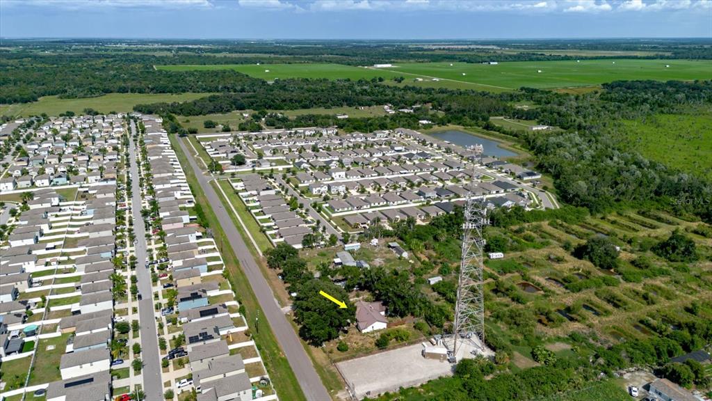 An aerial view shows a house with a yellow arrow pointing toward it near a tower — 11109 SUMNER ROAD, WIMAUMA, FL