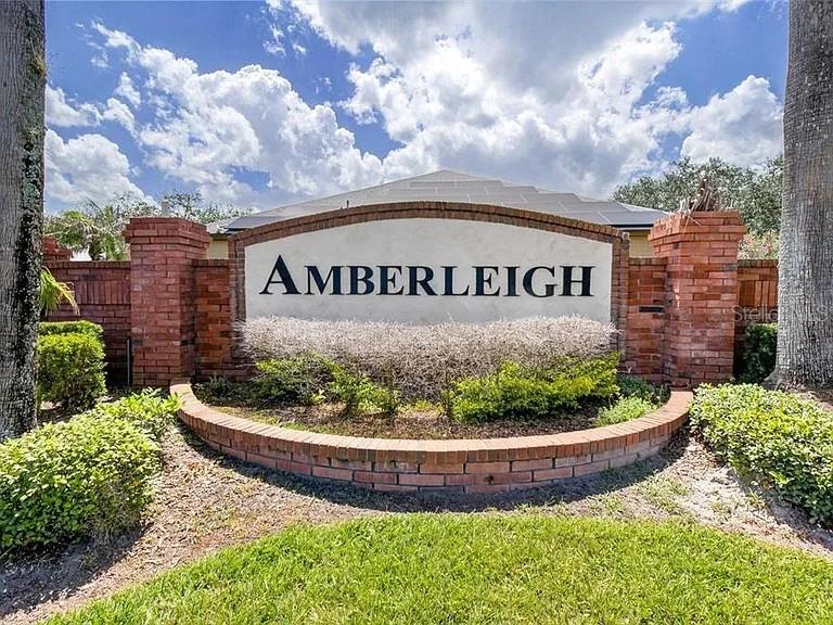 A two-story tan house with a brown roof, a two-car garage, and a front lawn — 353 LAKE AMBERLEIGH DRIVE, WINTER GARDEN, FL