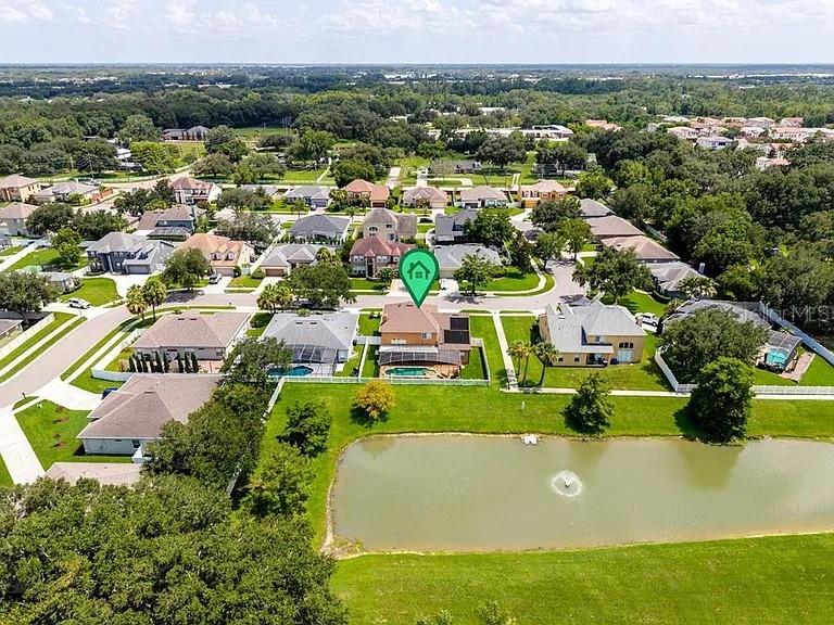 A screened-in patio features a swimming pool with water fountains and a white picket fence — 353 LAKE AMBERLEIGH DRIVE, WINTER GARDEN, FL