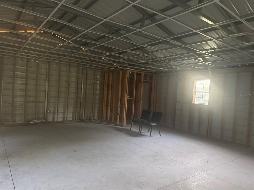 An unfinished interior space features metal wall framing, a grid ceiling, and a concrete floor — 7097 119TH ROAD, LIVE OAK, FL