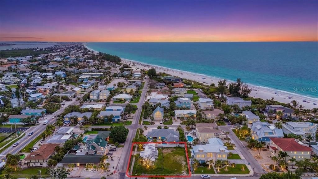 An aerial view shows a coastal residential lot outlined in red near a sandy beach — 121 48TH STREET, HOLMES BEACH, FL