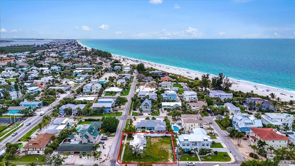 An aerial view shows a vacant, rectangular lot outlined in red near a sandy beach — 121 48TH STREET, HOLMES BEACH, FL