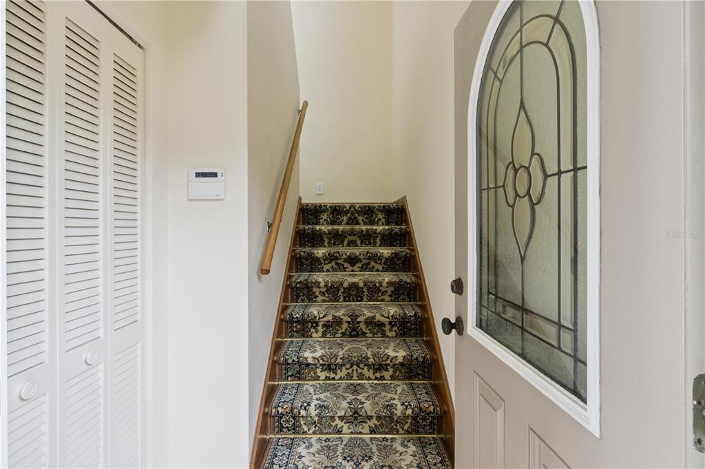 An entryway features a carpeted staircase, a louvered closet door, and a front door with glass — 75 SUNSET VIEW DRIVE UNIT 75, WINTER HAVEN, FL