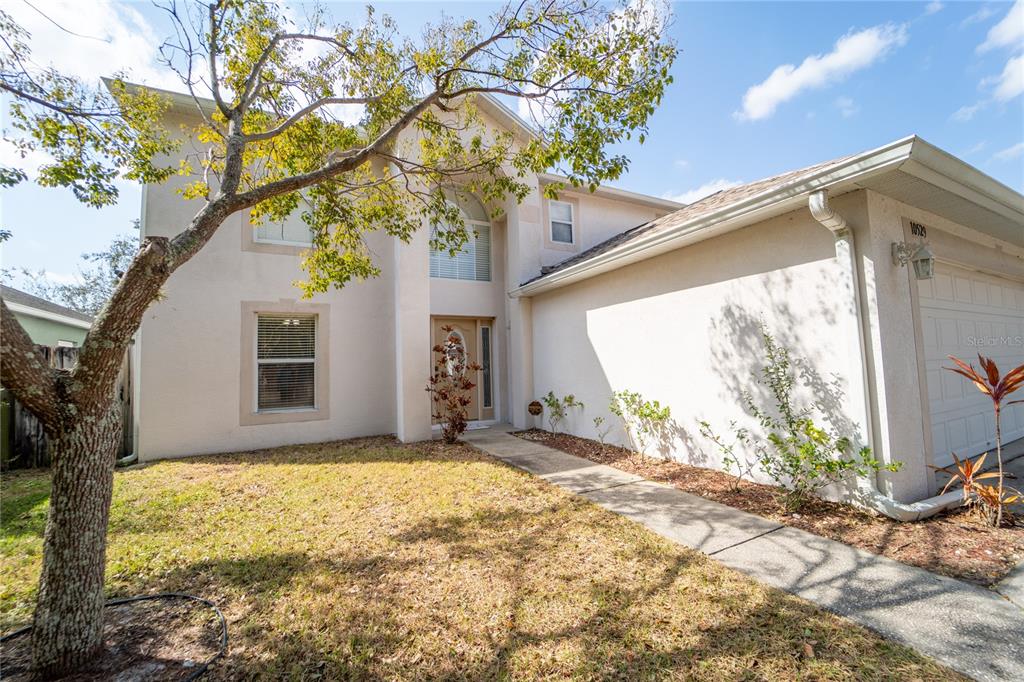 A two-story house with a beige stucco exterior, a front walkway, and a garage — 10529 MARONDA DRIVE, RIVERVIEW, FL