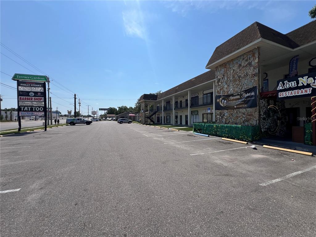 A two-story commercial building with a stone facade and parking lot under a clear sky — 4819 E BUSCH BOULEVARD, TAMPA, FL