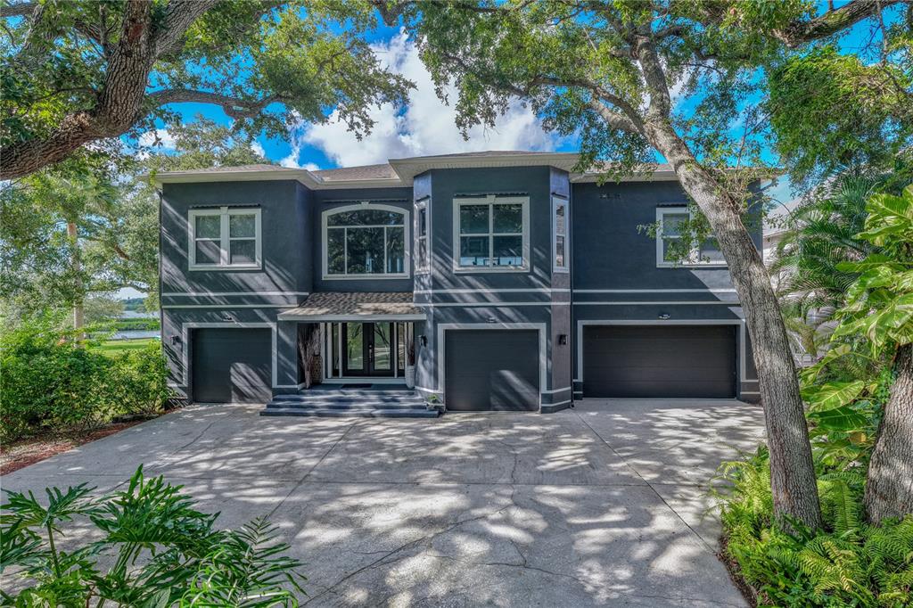 An aerial view shows a waterfront house surrounded by trees with a private dock — 3484 SHORE DRIVE, SAFETY HARBOR, FL