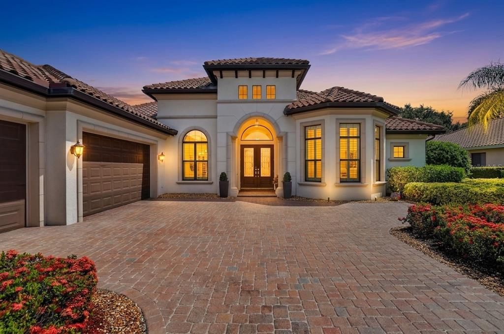 A Mediterranean-style house with a tiled roof, arched entryway, and a paved brick driveway — 11810 RIVER SHORES TRAIL, PARRISH, FL