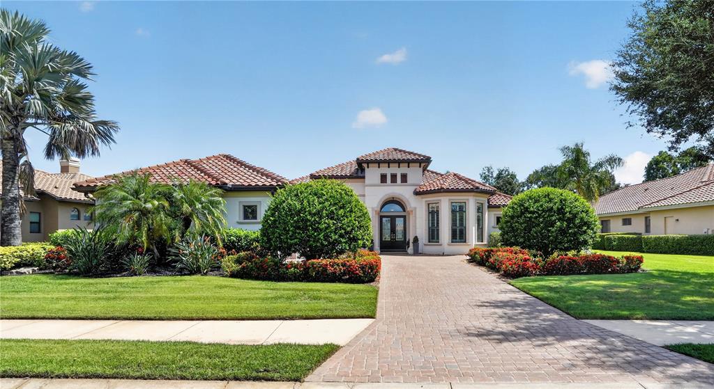 A single-story house with a brick paver driveway, tiled roof, and manicured landscaping — 11810 RIVER SHORES TRAIL, PARRISH, FL