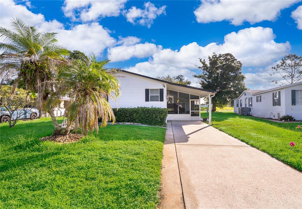 A single-story white house with a screened-in porch and a concrete driveway — 2721 DOWNING DRIVE, KISSIMMEE, FL