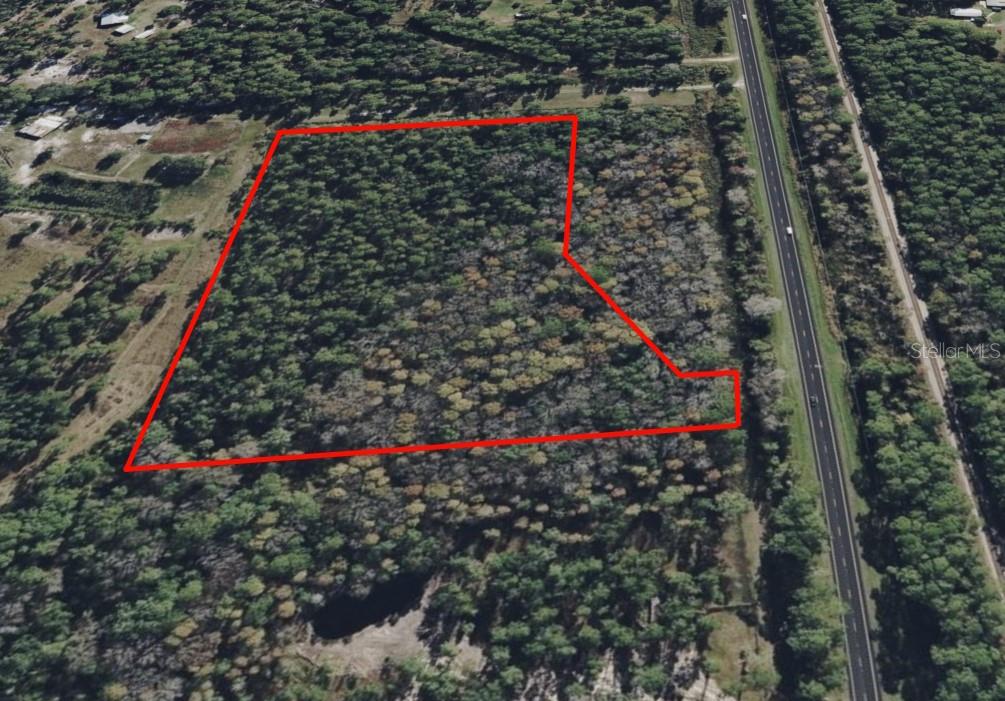 An aerial view shows a wooded plot of land outlined in red next to a highway — 000 S US HWY 17 HIGHWAY, PIERSON, FL
