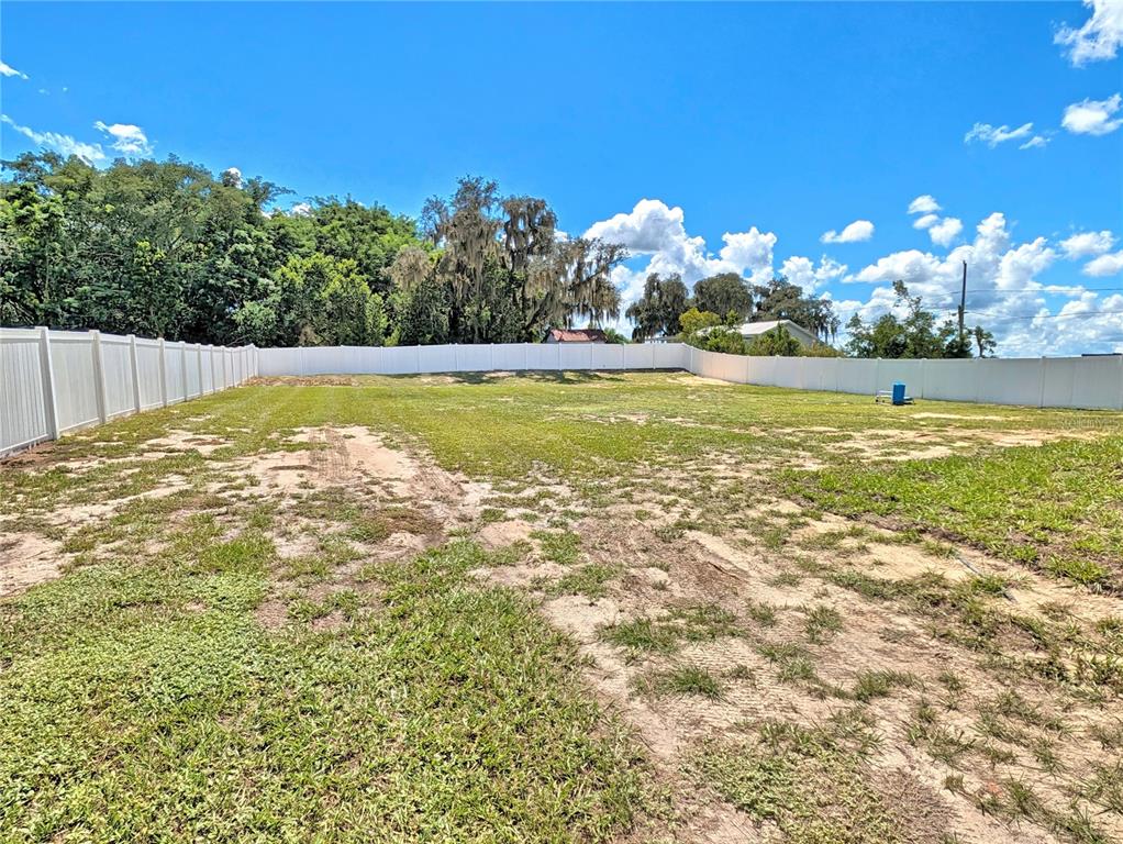 A single-story house with a screened porch sits on a large, sandy, open lot — 352 E HWY 630 E, FROSTPROOF, FL