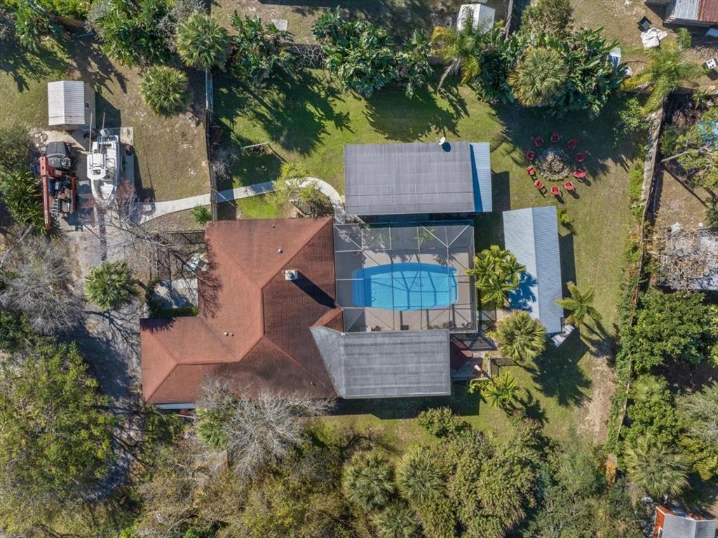 An aerial view shows a house with a red roof, a screened pool, and outbuildings — 281 OLD DIXIE HIGHWAY, VERO BEACH, FL