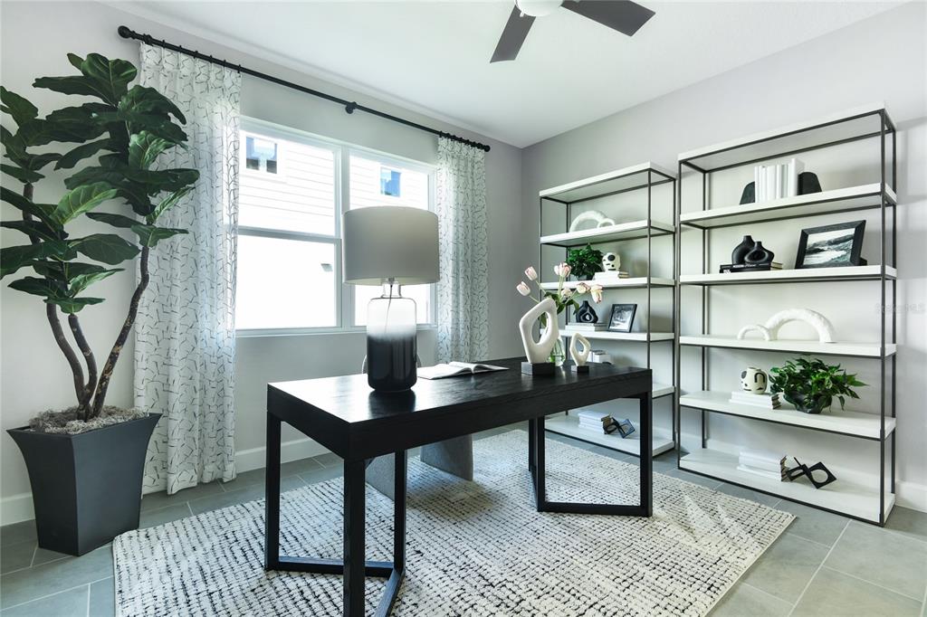 A home office features a dark desk, two metal shelving units, and a large potted plant — 3457 MACCHI AVENUE, TAVARES, FL