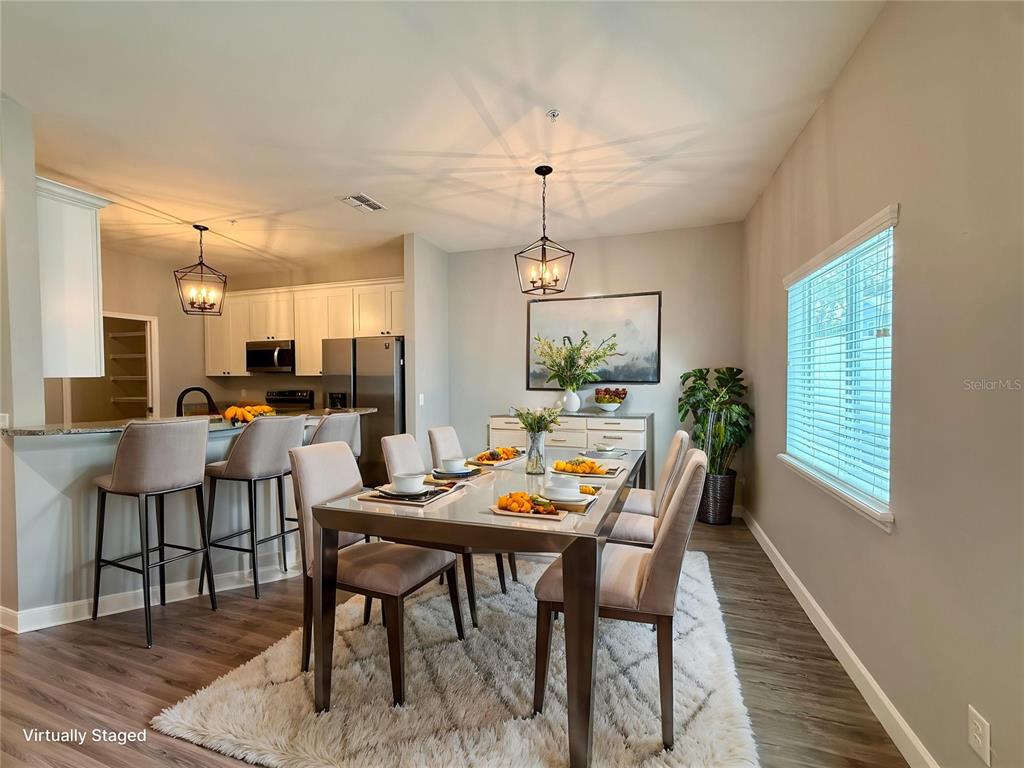 A living room with wood-look flooring, a ceiling fan, and an adjacent kitchen counter — 2531 PINE PLACE, WINTER HAVEN, FL
