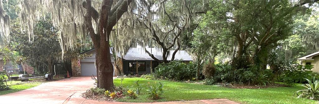 A single-story house with a garage and a large front yard shaded by mossy trees — 2430 W COUNTY ROAD 44, EUSTIS, FL